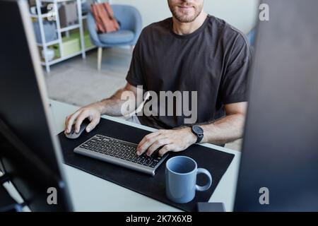 Close up of young Caucasian man typing at keyboard while programming software, copy space Stock Photo