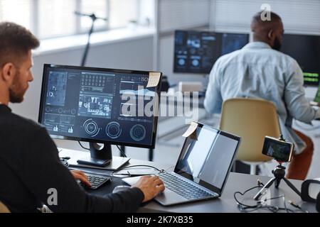 Portrait of male programmer or data specialist using computer in office with charts on screen, copy space Stock Photo