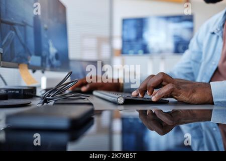 Close up of black man playing shooter video game with focus on hands at keyboard, copy space Stock Photo