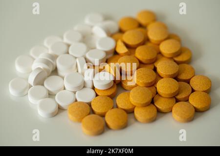 Yellow and white pills on a grey surface. Stock Photo