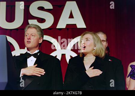 U.S. President Bill Clinton and First Lady Hillary Clinton sing the national anthem at the fourth annual Olympic gala dinner in support of the U.S Olympic team at the Washington Hilton Hotel, May 1, 1996 in Washington, D.C. The centennial Olympic games will be held in Atlanta in August. Stock Photo