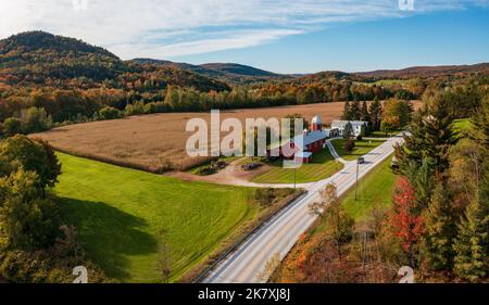Aerial view of large red farm barn by the side of the road near Montgomery in Vermont during the autumn color season Stock Photo