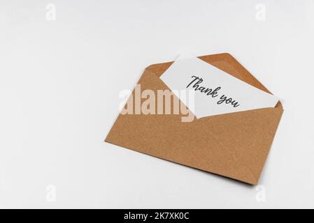 Thank you message in brown envelope on white background Stock Photo