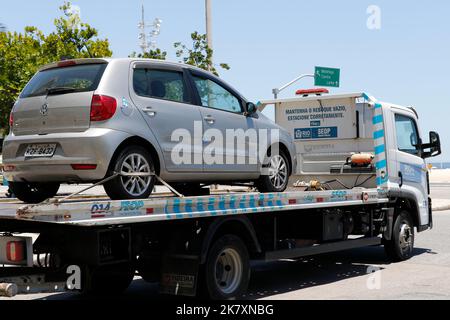 Tow truck towing impounded vehicles for traffic violations. Illegal parking, punishment and fine for irregular driving Stock Photo