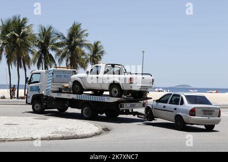 Tow truck towing impounded vehicles for traffic violations. Illegal parking, punishment and fine for irregular driving Stock Photo