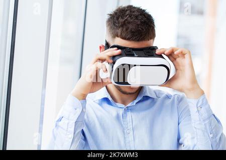 Man in virtual reality glasses interacts with app simulated interface. Stock Photo