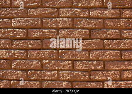 brown painted brick wall, retro style rough stone decorative facade texture close up view. Stock Photo