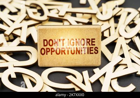 Education concept. Among the wooden letters is a sign with the inscription - Don't Ignore Opportunities Stock Photo