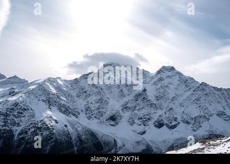 View of the mountain range, steep slopes and snow-capped rocky peaks. Stock Photo