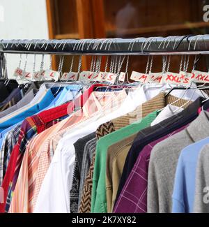 vintage used clothes and new dresses in the stall at market Stock Photo