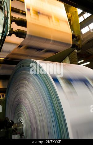 Close-up to the printed material coming out from a printing press machine Stock Photo