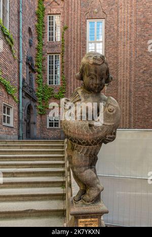 Sweden, Stockholm - July 16, 2022: City Hall or Stadshuset. Statue by Marcus Loveblad of child with giant fish at stairway on NE side of courtyard. Gr Stock Photo