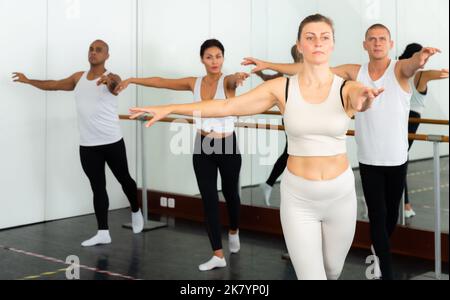 Concentrated women and men rehearsing ballet dance Stock Photo