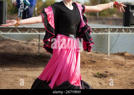Gypsy dances in bright dresses. Girls dance on street Spanish dance. Bright fabric. Dance moves. Stock Photo