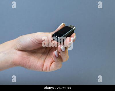 USB Type C adapter or hub with various accessories - pendrives, hdmi, ethernet, memory card, cables. Hands holding various converter cables for comput Stock Photo