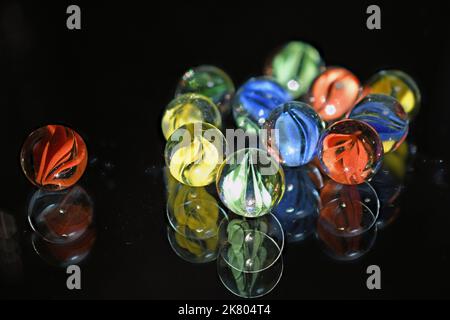 Vintage glass children's marbles on black glass Stock Photo