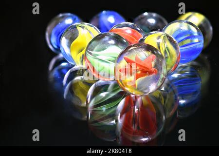 Vintage glass children's marbles on black glass Stock Photo