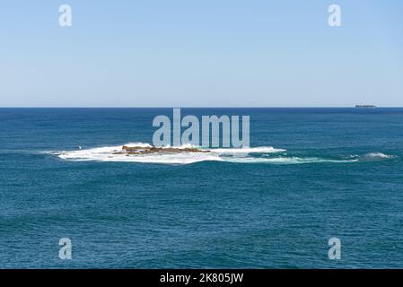 Waves crashing onto Wedding Cake Island in the Tasman Sea Stock Photo