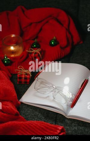 Christmas composition with notebook, pen, glasses, candle and decor Stock Photo