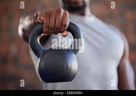 Fitness, bodybuilder and black man kettlebell training, exercise or workout for powerful arm strength at gym. African, hand and strong sports athlete Stock Photo