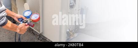 Technician checking the operation of the air conditioner Stock Photo