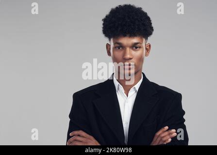 Get real or go home. Studio portrait of a confident young businessman posing against a grey background. Stock Photo