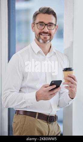 Starting my day the right way. a businessman using his smartphone while drinking coffee. Stock Photo