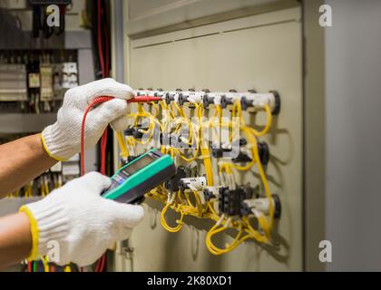 An electrical engineer is inspecting the operation of an electrical control cabinet. maintenance concept Stock Photo