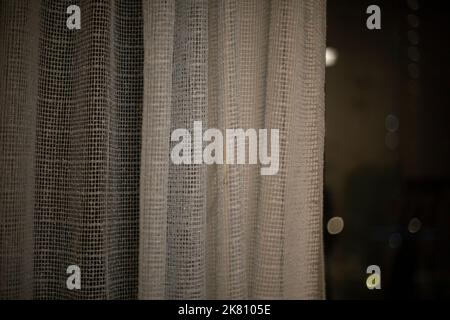 Curtains on window in evening. Fabric covers window. Interior details. Stock Photo