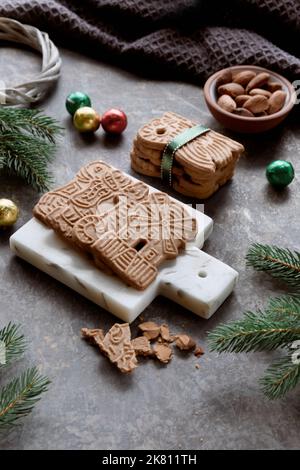 Speculoos or Spekulatius, Christmas biscuits, chocolate balls and almonds on a table with fir twigs. Traditional German sweets, cookies for Christmas Stock Photo