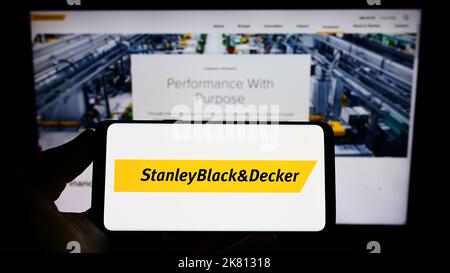 https://l450v.alamy.com/450v/2k81318/person-holding-cellphone-with-logo-of-american-tools-company-stanley-black-and-decker-inc-on-screen-in-front-of-webpage-focus-on-phone-display-2k81318.jpg