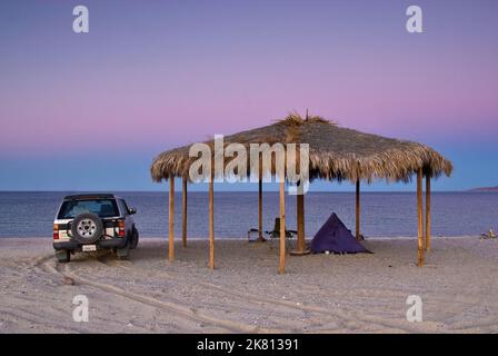 Camper at palapa on beach after sunset at Bahia San Luis Gonzaga at Campo Rancho Grande, Baja California, Mexico Stock Photo
