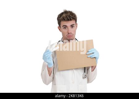 Young sad doctor hold a board and positive covid-19 antigen test, isolated. Stock Photo