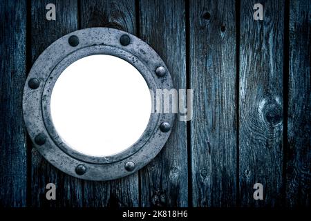 Close-up of an old rusty closed empty porthole window. Old blue rich wood grain texture background with knots. Stock Photo