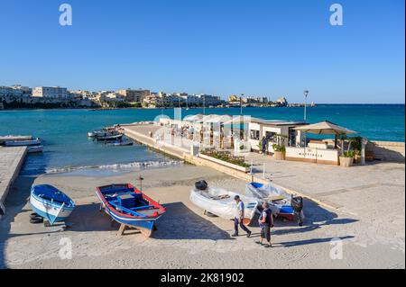 Outdoor restaurant Maestrale sits on a pier with a view across the bay to the north side of Otranto town, Apulia (Puglia), Italy. Stock Photo