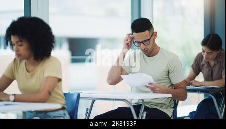 Ignorance is just an absence of effort. focused students completing an exam at university. Stock Photo