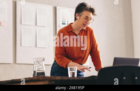 Mature businesswoman talking to her client during a video conference. Female interior designer pitching her idea in an online meeting. Mature business Stock Photo