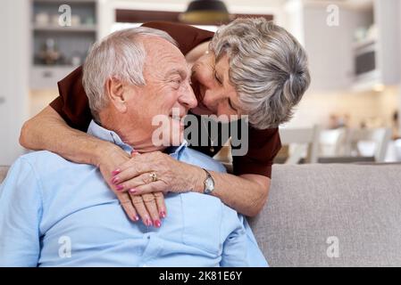 Hows that for gratitude. an elderly couple being affectionate on the sofa at home. Stock Photo
