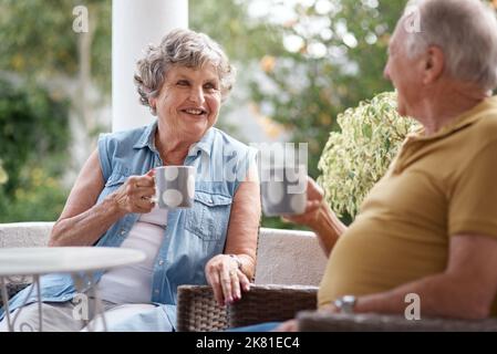 The shape of a cloud, the smell of an idea. a senior couple having coffee and sharing a conversation in a garden. Stock Photo