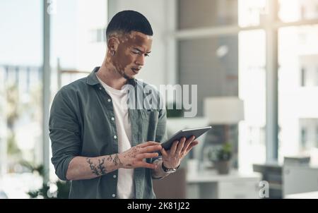 Know something nobody else knows. a young business man using a tablet at work. Stock Photo