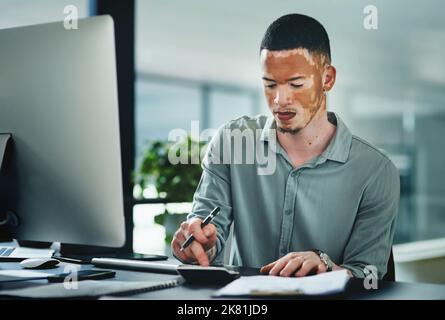 I have to use a calculator just to be sure. a young businessman using a calculator while doing paperwork in an office at work. Stock Photo