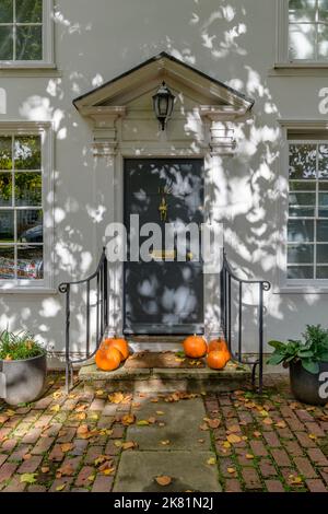 Autumn display of pumpkins and falling leaves on the door step of a Georgian house in the pretty town of Tenterden in Kent UK, ready for halloween! Stock Photo