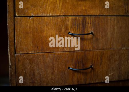Drawer in table. Wooden boxes in room. Handles on board. Interior details. Stock Photo