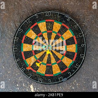 Dart board detail with darts on wall Stock Photo