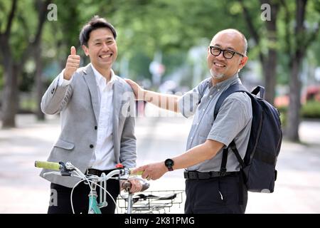 Smiling Japanese men with bike Stock Photo