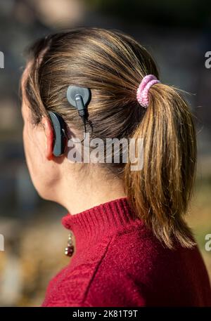 Woman head with cochleral implant hearing aid outdoor Stock Photo