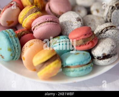 Heap of colorful french macarons on plate Stock Photo