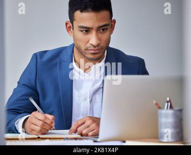 This presentation could make or break the business. a young businessman taking notes while using his laptop. Stock Photo