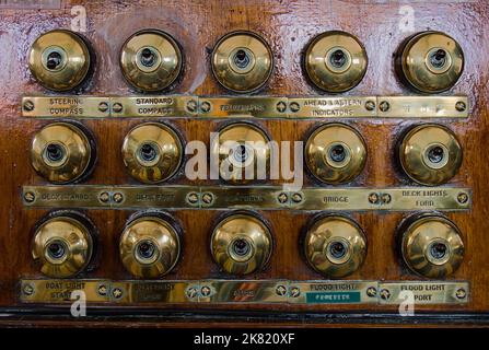 Bank Of Old Brass Light Switches On Wood On The Bridge Of The SS Sheildhall Steam Ship, Southampton UK Stock Photo