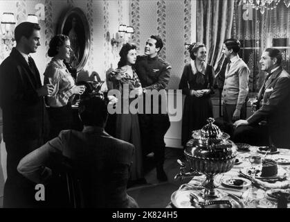 Ingrid Bergman, Susan Hayward, Johnny Downs & Warner Baxter Film: Adam Had Four Sons (USA 1941) Characters: Emilie Gallatin, Hester Stoddard, David Stoddard (older), Adam Stoddard  Director: Gregory Ratoff 18 February 1941   **WARNING** This Photograph is for editorial use only and is the copyright of COLUMBIA and/or the Photographer assigned by the Film or Production Company and can only be reproduced by publications in conjunction with the promotion of the above Film. A Mandatory Credit To COLUMBIA is required. The Photographer should also be credited when known. No commercial use can be gra Stock Photo